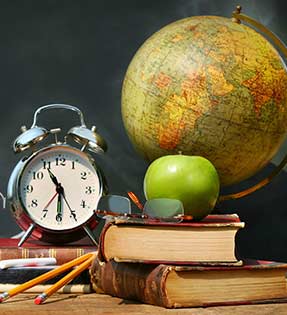 Clock, apple, globe and books