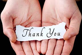 Hands holding a paper saying thank you