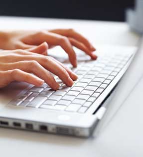 Fingers typing on a laptop keyboard