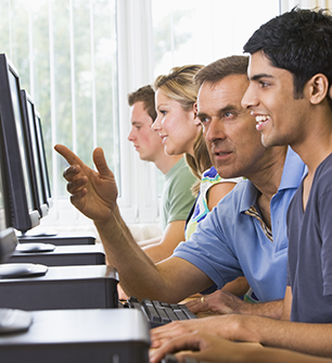 Teacher helps students with computers